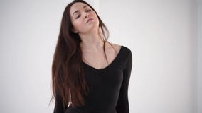 La giovane e donna graziosa che fa il riscaldamento con i tudies, si scalda i muscoli video d archivio La giovane e donna graziosa che fa il riscaldamento con i tudies, si scalda i muscoli video d archivio