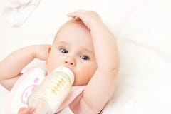 La giovane madre sta alimentando il suo bambino a stanza fotografie stock La giovane madre sta alimentando il suo bambino a stanza fotografie stock