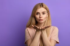 La giovane ragazza bionda con le palme davanti al suo petto esprime la sua sensibilità fotografia stock libera da diritti La giovane ragazza bionda con le palme davanti al suo petto esprime la sua sensibilità fotografia stock libera da diritti