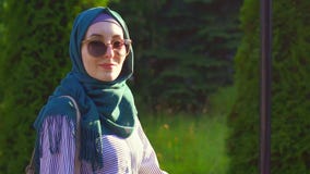 La giovane ragazza musulmana attraente nel hijab va ed esamina la macchina fotografica Mo lento archivi video La giovane ragazza musulmana attraente nel hijab va ed esamina la macchina fotografica Mo lento archivi video