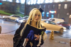 La giovane signora si è vestita in costume nero, avendo libro in mani immagine stock La giovane signora si è vestita in costume nero, avendo libro in mani immagine stock