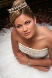La giovane sposa si è vestita nella seduta bianca sul pavimento immagine stock La giovane sposa si è vestita nella seduta bianca sul pavimento immagine stock