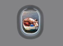 La hembra joven miente en un barco de madera en puesta del sol en la ventana plana Visión desde la ventana del aeroplano