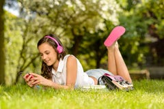 La hierba de mentira de la muchacha del verano escucha los auriculares de la música Foto de archivo La hierba de mentira de la muchacha del verano escucha los auriculares de la música Foto de archivo