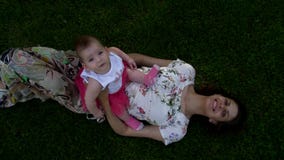 La hija se está sentando en su mamá y sonrisa La hija se está sentando en su mamá y sonrisa