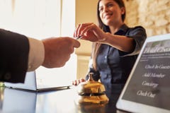 La huésped coge la llave electrónica del sitio en el mostrador de facturación del hotel, cierre La huésped coge la llave electrónica del sitio en el mostrador de facturación del hotel, cierre