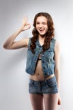 La imagen de la chica joven alegre muestra la AUTORIZACIÓN del gesto imágenes de archivo libres de regalías La imagen de la chica joven alegre muestra la AUTORIZACIÓN del gesto imágenes de archivo libres de regalías