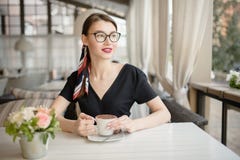 La jeune belle femme avec un sourire s'assied sur la rue et le café de boissons Café lumineux d'été image stock La jeune belle femme avec un sourire s'assied sur la rue et le café de boissons Café lumineux d'été image stock