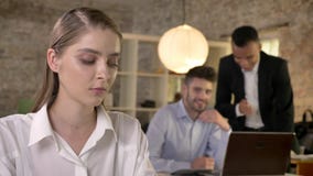 La jeune belle femme d'affaires écoute comment ses collègues d'hommes sur le fond bavardent au sujet du herm, concept de sexisme banque de vidéos La jeune belle femme d'affaires écoute comment ses collègues d'hommes sur le fond bavardent au sujet du herm, concept de sexisme banque de vidéos