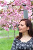 La jeune belle fille avec de longs cheveux blonds appr?cie la beaut? de la nature de ressort pr?s de l'arbre de floraison de Saku photo stock La jeune belle fille avec de longs cheveux blonds appr?cie la beaut? de la nature de ressort pr?s de l'arbre de floraison de Saku photo stock