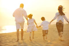 La jeune famille heureuse ont l'amusement sur la plage au coucher du soleil images libres de droits La jeune famille heureuse ont l'amusement sur la plage au coucher du soleil images libres de droits