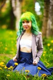 La jeune femme alternative de beau hippie avec les cheveux jaunes s'assied dans l'herbe avec le pissenlit en parc photo stock La jeune femme alternative de beau hippie avec les cheveux jaunes s'assied dans l'herbe avec le pissenlit en parc photo stock