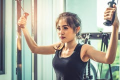 La jeune femme asiatique faisant la corde ?lastique s'exerce au gymnase crois? de forme physique Formation de force et musculaire photo stock La jeune femme asiatique faisant la corde ?lastique s'exerce au gymnase crois? de forme physique Formation de force et musculaire photo stock