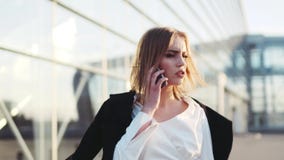 La jeune femme blonde chaude parle à son téléphone, vérifie le temps, touche ses cheveux Le terminal d'aéroport sur le fond clips vidéos La jeune femme blonde chaude parle à son téléphone, vérifie le temps, touche ses cheveux Le terminal d'aéroport sur le fond clips vidéos