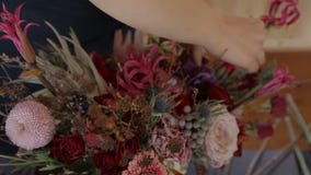 La jeune femme crée le beau bouquet dans l'atelier de magasin banque de vidéos La jeune femme crée le beau bouquet dans l'atelier de magasin banque de vidéos