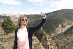 La jeune femme de hippie fait un selfie sur le dessus du paysage étonnant de gamme de montagne de falaise hippie aventure Voyage Image stock La jeune femme de hippie fait un selfie sur le dessus du paysage étonnant de gamme de montagne de falaise hippie aventure Voyage Image stock