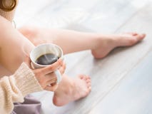 La jeune femme détend à la maison et boit du café parfumé Beaux pieds femelles de plan rapproché humain méconnaissable cultivé photographie stock libre de droits La jeune femme détend à la maison et boit du café parfumé Beaux pieds femelles de plan rapproché humain méconnaissable cultivé photographie stock libre de droits