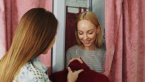 La jeune femme gaie apparaît par derrière le rideau de la cabine d'essayage tandis que l'employé de magasin donne son nouveau pul banque de vidéos La jeune femme gaie apparaît par derrière le rideau de la cabine d'essayage tandis que l'employé de magasin donne son nouveau pul banque de vidéos