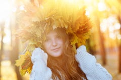 La jeune femme heureuse avec une guirlande de jaune laisse la marche dans le parc photos stock La jeune femme heureuse avec une guirlande de jaune laisse la marche dans le parc photos stock