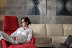 La jeune femme heureuse détendent à la maison sur le sofa photos stock La jeune femme heureuse détendent à la maison sur le sofa photos stock