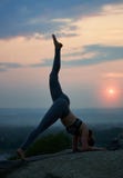 La jeune femme mince attirante faisant le yoga s'exerce dehors sur le fond du beau ciel photo stock La jeune femme mince attirante faisant le yoga s'exerce dehors sur le fond du beau ciel photo stock