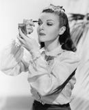 La jeune femme regardant dans un miroir et mettant dessus composent (toutes les personnes représentées ne sont pas plus long viva Image libre de droits La jeune femme regardant dans un miroir et mettant dessus composent (toutes les personnes représentées ne sont pas plus long viva Image libre de droits