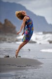 La jeune femme sautant sur la plage dans la soirée d'été photos stock La jeune femme sautant sur la plage dans la soirée d'été photos stock