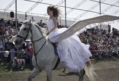 La jeune fille avec de grandes ailes derrière elle de retour monte sur un cheval blanc photo libre de droits La jeune fille avec de grandes ailes derrière elle de retour monte sur un cheval blanc photo libre de droits