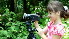 La jeune fille regarde dans la caméra vidéo sur le fond du fond vert de parc banque de vidéos La jeune fille regarde dans la caméra vidéo sur le fond du fond vert de parc banque de vidéos