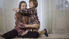 La jeune fille s'asseyent sur la couverture pelucheuse dans le salon et son frère viennent pour la caresser Amour et bonheur de f banque de vidéos La jeune fille s'asseyent sur la couverture pelucheuse dans le salon et son frère viennent pour la caresser Amour et bonheur de f banque de vidéos
