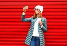 La jolie femme de mode prend un autoportrait de photo sur un smartphone Image stock La jolie femme de mode prend un autoportrait de photo sur un smartphone Image stock