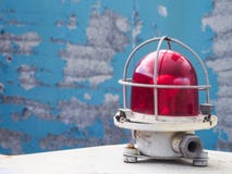 La lampadina di segnalazione Luce d'avvertimento rossa su un fondo blu Il concetto di sicurezza immagine stock libera da diritti La lampadina di segnalazione Luce d'avvertimento rossa su un fondo blu Il concetto di sicurezza immagine stock libera da diritti