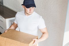 La livraison forte, bo?tes en carton musculaires de chargement d'homme pour se d?placer ? un appartement travailleur professionne image stock La livraison forte, bo?tes en carton musculaires de chargement d'homme pour se d?placer ? un appartement travailleur professionne image stock