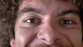 La longueur étroite de l'homme fol observe regardant l'appareil-photo et souriant, les cheveux bouclés avec le volume banque de vidéos La longueur étroite de l'homme fol observe regardant l'appareil-photo et souriant, les cheveux bouclés avec le volume banque de vidéos