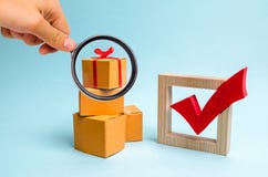 La loupe regarde le boîte-cadeau sur une pile des boîtes et d'un coche rouge concept de trouver le cadeau parfait Achats photo stock La loupe regarde le boîte-cadeau sur une pile des boîtes et d'un coche rouge concept de trouver le cadeau parfait Achats photo stock