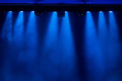 La luz azul de los proyectores a través del humo en el teatro durante el funcionamiento fotos de archivo La luz azul de los proyectores a través del humo en el teatro durante el funcionamiento fotos de archivo