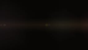 La luz ámbar de mudanza con la lente óptica del fondo negro señala por medio de luces animación La luz ámbar de mudanza con la lente óptica del fondo negro señala por medio de luces animación