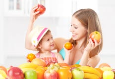 La madre della famiglia e la bambina felici della figlia, mangiano l'alimento vegetariano sano, frutta fotografie stock libere da diritti La madre della famiglia e la bambina felici della figlia, mangiano l'alimento vegetariano sano, frutta fotografie stock libere da diritti
