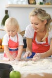 La madre e la piccola figlia stanno cucinando nella cucina Spendendo tempo tutto insieme o concetto 'nucleo familiare' felice Fotografie Stock La madre e la piccola figlia stanno cucinando nella cucina Spendendo tempo tutto insieme o concetto 'nucleo familiare' felice Fotografie Stock