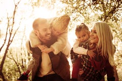 La madre ed il padre che portano le loro figlie sopra trasportano sulle spalle fotografia stock libera da diritti La madre ed il padre che portano le loro figlie sopra trasportano sulle spalle fotografia stock libera da diritti
