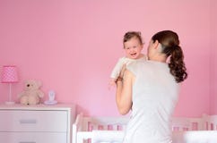 La madre joven pone a su bebé para dormir foto de archivo La madre joven pone a su bebé para dormir foto de archivo