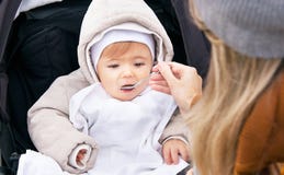 La madre sta alimentando il neonato di nove mesi da un cucchiaio Immagini Stock Libere da Diritti La madre sta alimentando il neonato di nove mesi da un cucchiaio Immagini Stock Libere da Diritti