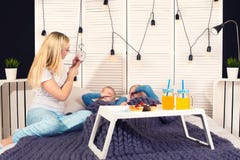 La madre sveglia i suoi figli cari Prima colazione a letto per i bambini, sorpresa immagini stock La madre sveglia i suoi figli cari Prima colazione a letto per i bambini, sorpresa immagini stock