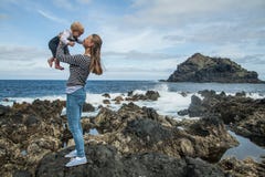 La madre y el bebé juegan cerca de la orilla de mar en Garachico foto de archivo libre de regalías La madre y el bebé juegan cerca de la orilla de mar en Garachico foto de archivo libre de regalías