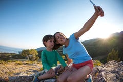 La madre y el hijo hacen el selfie encima de una montaña Fotos de archivo libres de regalías La madre y el hijo hacen el selfie encima de una montaña Fotos de archivo libres de regalías