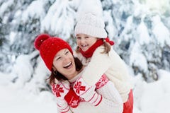 La madre y el niño en sombreros hechos punto del invierno juegan en nieve el vacaciones de la Navidad de la familia Sombrero y bu fotografía de archivo La madre y el niño en sombreros hechos punto del invierno juegan en nieve el vacaciones de la Navidad de la familia Sombrero y bu fotografía de archivo
