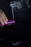 La main d'une femme avec un bel anneau argent? tient une bougie pourpre de tabagisme image stock La main d'une femme avec un bel anneau argent? tient une bougie pourpre de tabagisme image stock