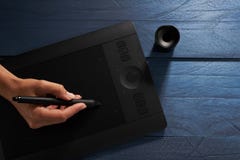 La main dessine une tablette graphique professionnelle noire photo stock La main dessine une tablette graphique professionnelle noire photo stock