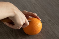 La main humaine juge le couteau et les coupes oranges sur la table en bois photo libre de droits La main humaine juge le couteau et les coupes oranges sur la table en bois photo libre de droits