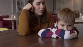 La maman calme le petit fils qui a été offensé par sa séance à une table dans un café banque de vidéos La maman calme le petit fils qui a été offensé par sa séance à une table dans un café banque de vidéos